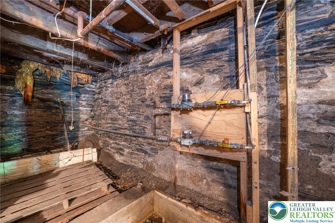 313 Main Street Slatington, PA 18080 - Photo 63 of 73 Exposed stone walls define this unfinished basement, offering raw potential for future development.
