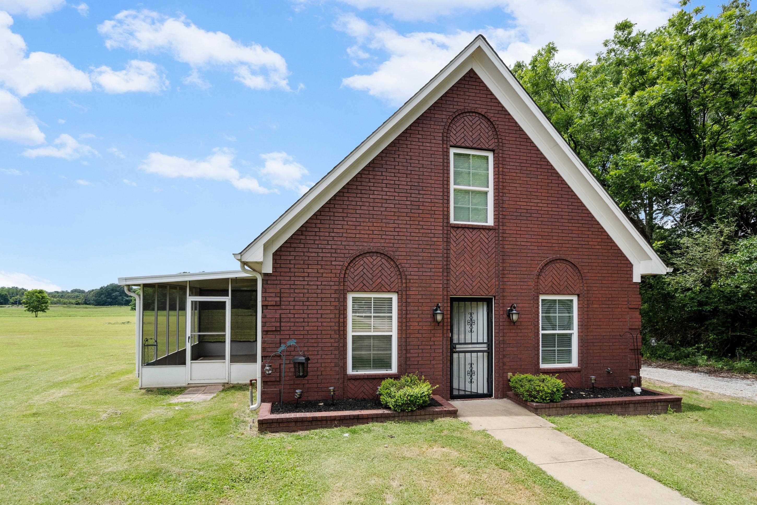 7757 Brunswick Road Millington, TN 38053 - Photo 23 of 40 Brick exterior featuring a screened porch, gabled roofline, and front entry with wrought iron security door