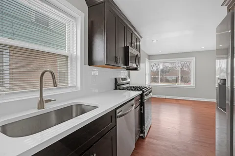 a kitchen with a sink stove top oven and refrigerator