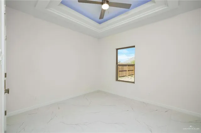 an empty room with windows and fan