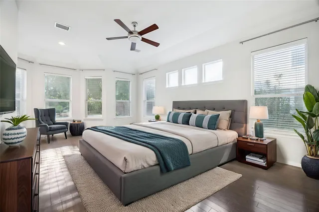 a spacious bedroom with a bed a couch and a potted plant