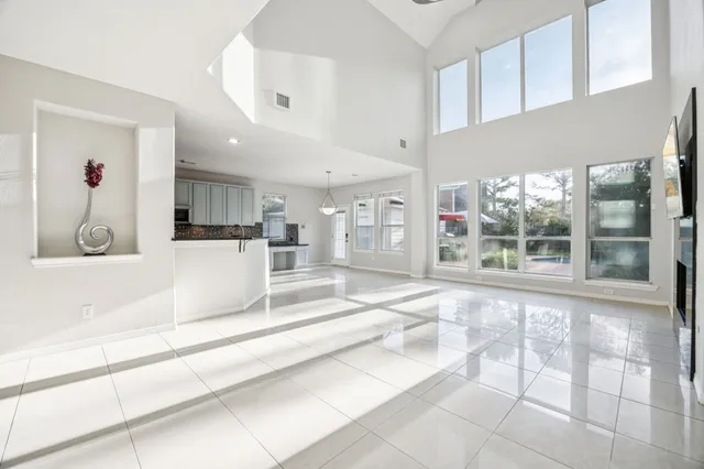 a large white kitchen with kitchen island and a sink