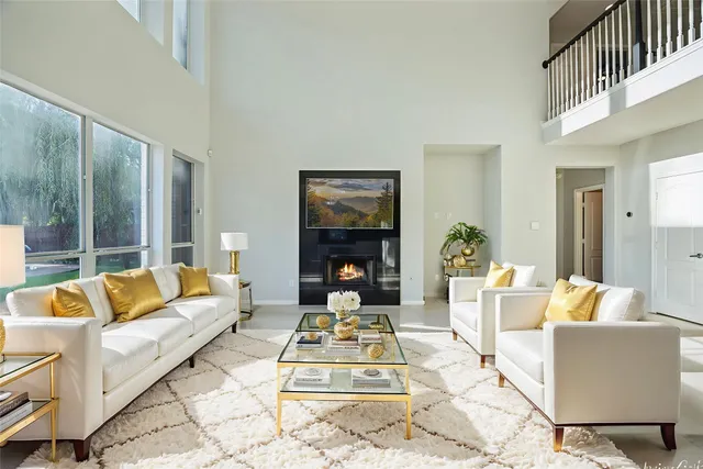 a living room with furniture large window and a fireplace