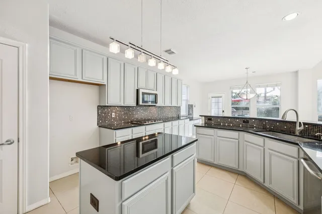 a kitchen with stainless steel appliances granite countertop a sink stove and cabinets
