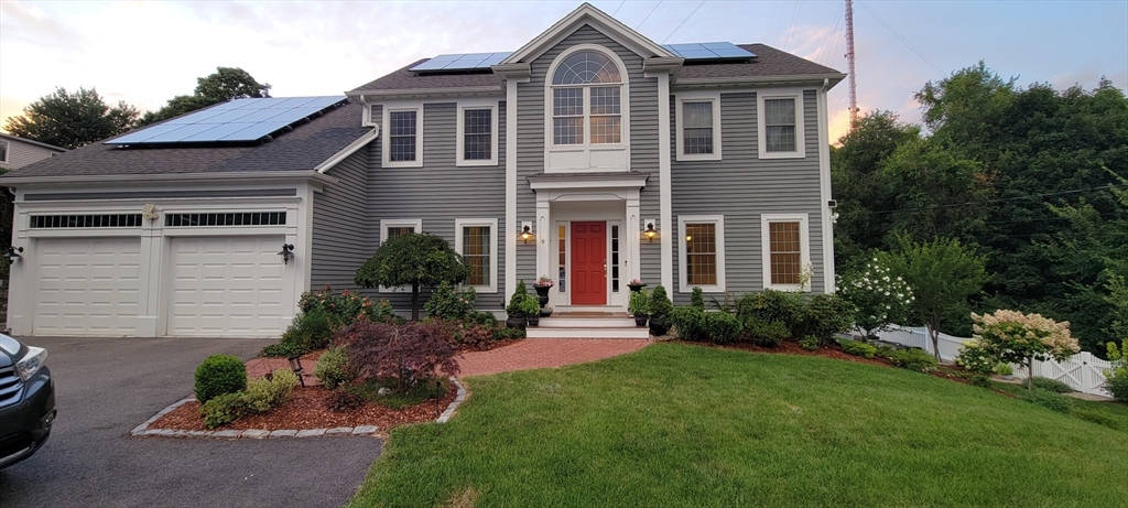 a front view of a house with a garden and plants