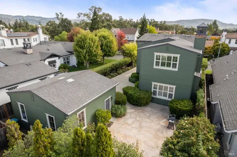 an aerial view of a house with a yard and mountain view in back