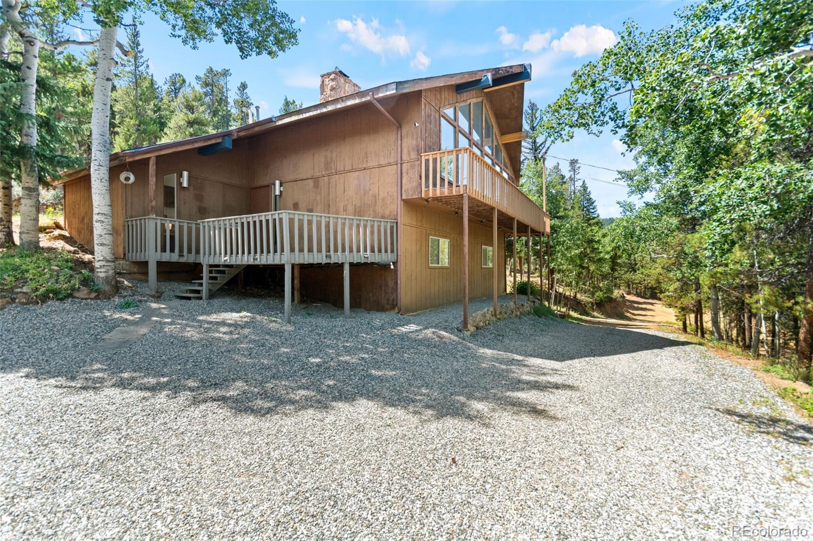 a view of a house with a yard and a large tree
