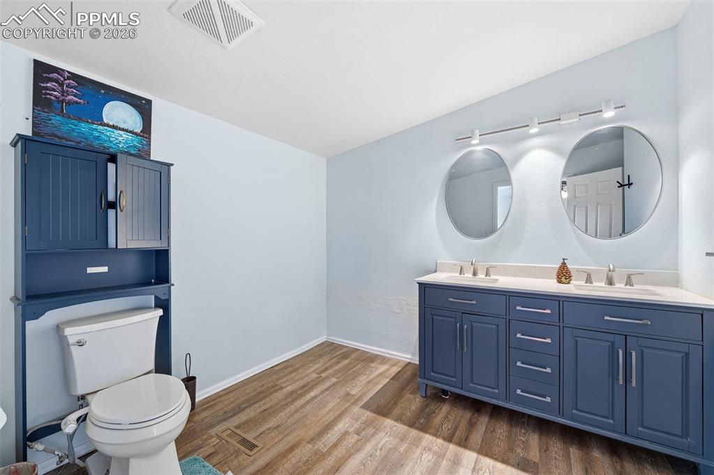 5535 Peerless Farms Road Peyton, CO 80831 - Photo 14 of 27 a bathroom with a toilet a sink and mirror