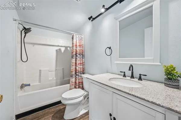 a bathroom with a granite countertop sink toilet and shower