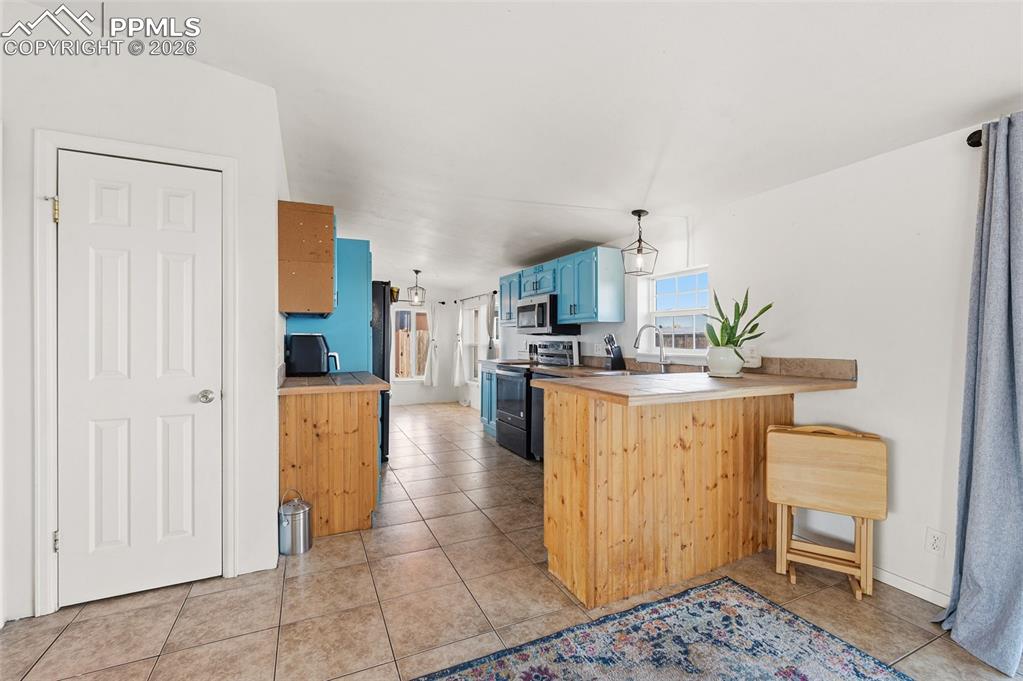 5535 Peerless Farms Road Peyton, CO 80831 - Photo 8 of 27 a kitchen with stainless steel appliances a refrigerator a sink a stove top oven