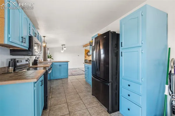 a kitchen with stainless steel appliances granite countertop a refrigerator a stove and a sink