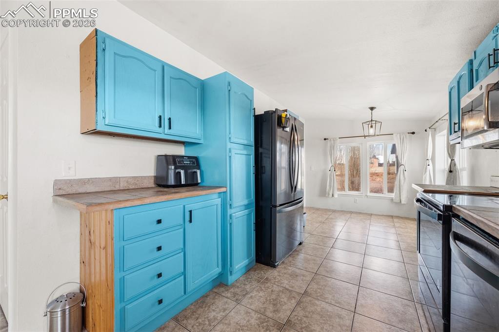 5535 Peerless Farms Road Peyton, CO 80831 - Photo 10 of 27 a kitchen with a refrigerator and cabinets
