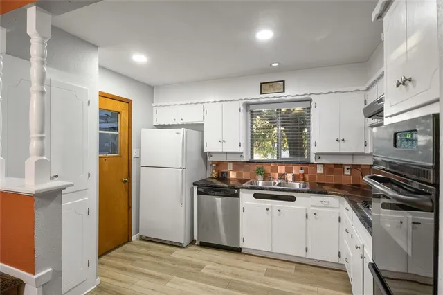 a kitchen with a refrigerator a stove a microwave and wooden floor