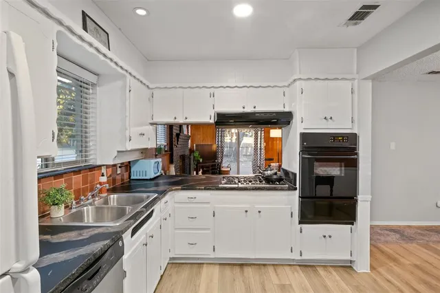 a kitchen with granite countertop a sink and cabinets