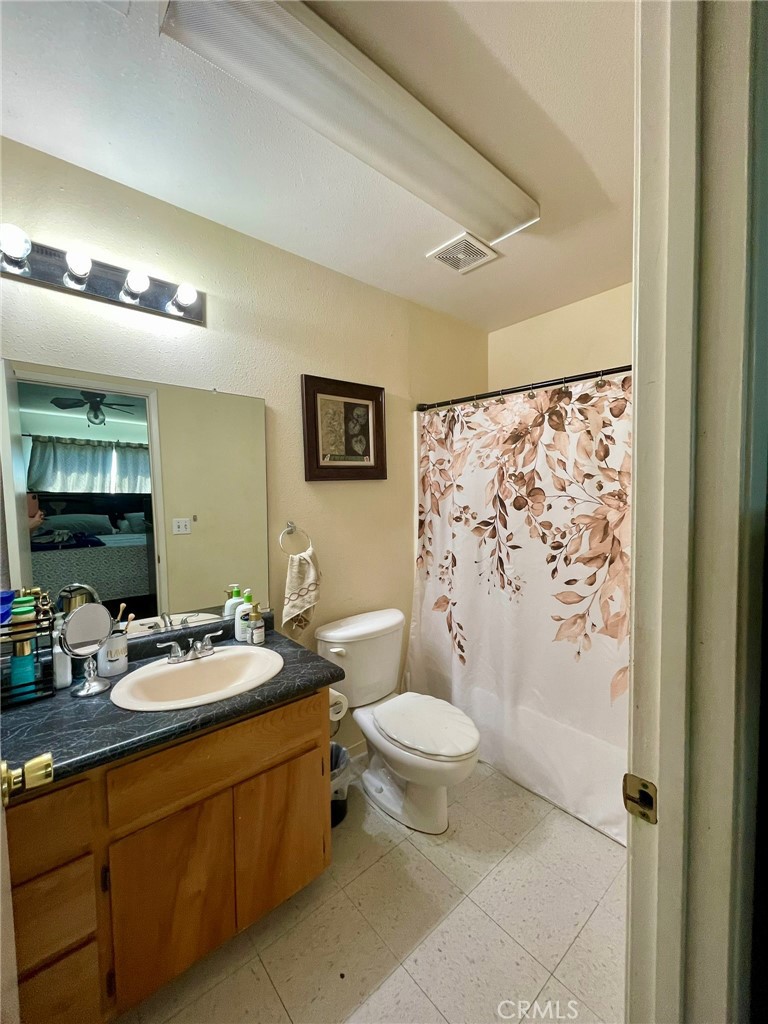 9654 Timothy Court Delhi, CA 95315 - Photo 11 of 18 a bathroom with a granite countertop sink toilet and shower