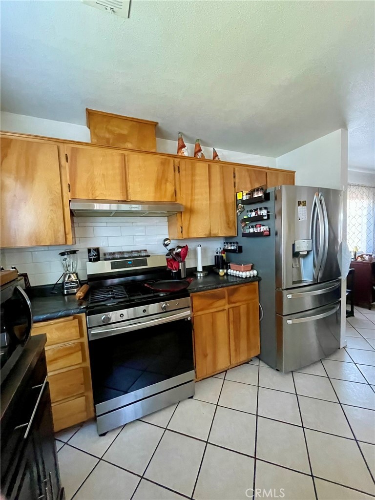 9654 Timothy Court Delhi, CA 95315 - Photo 4 of 18 a kitchen with stainless steel appliances granite countertop a stove a sink and a refrigerator