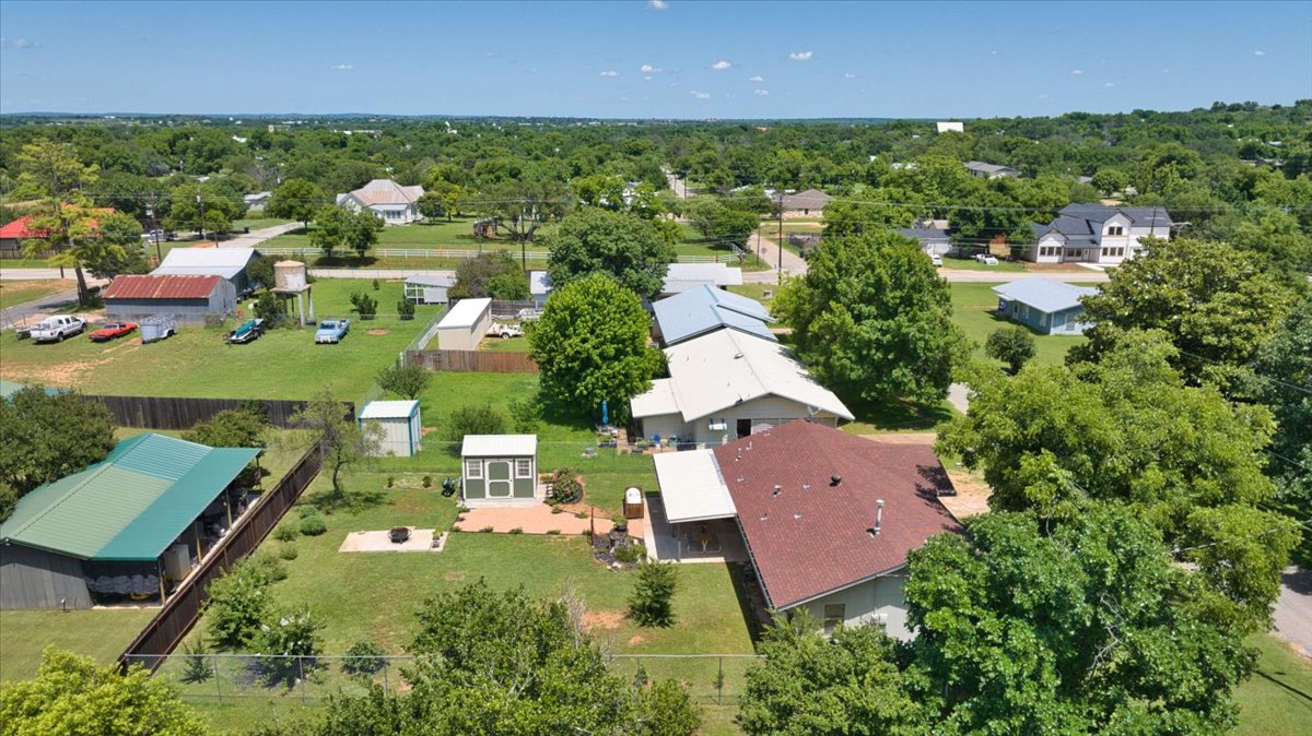 1236 Martin Street Mason, TX 76856 - Photo 36 of 40 An aerial panorama reveals a sprawling landscape of residential properties nestled among lush greenery, offering both privacy and community access.