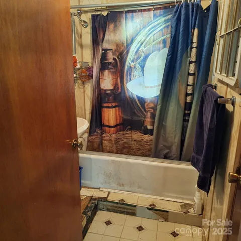 a bathroom with a tub sink and mirror
