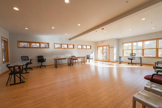 a view of a room with gym equipment and wooden floor