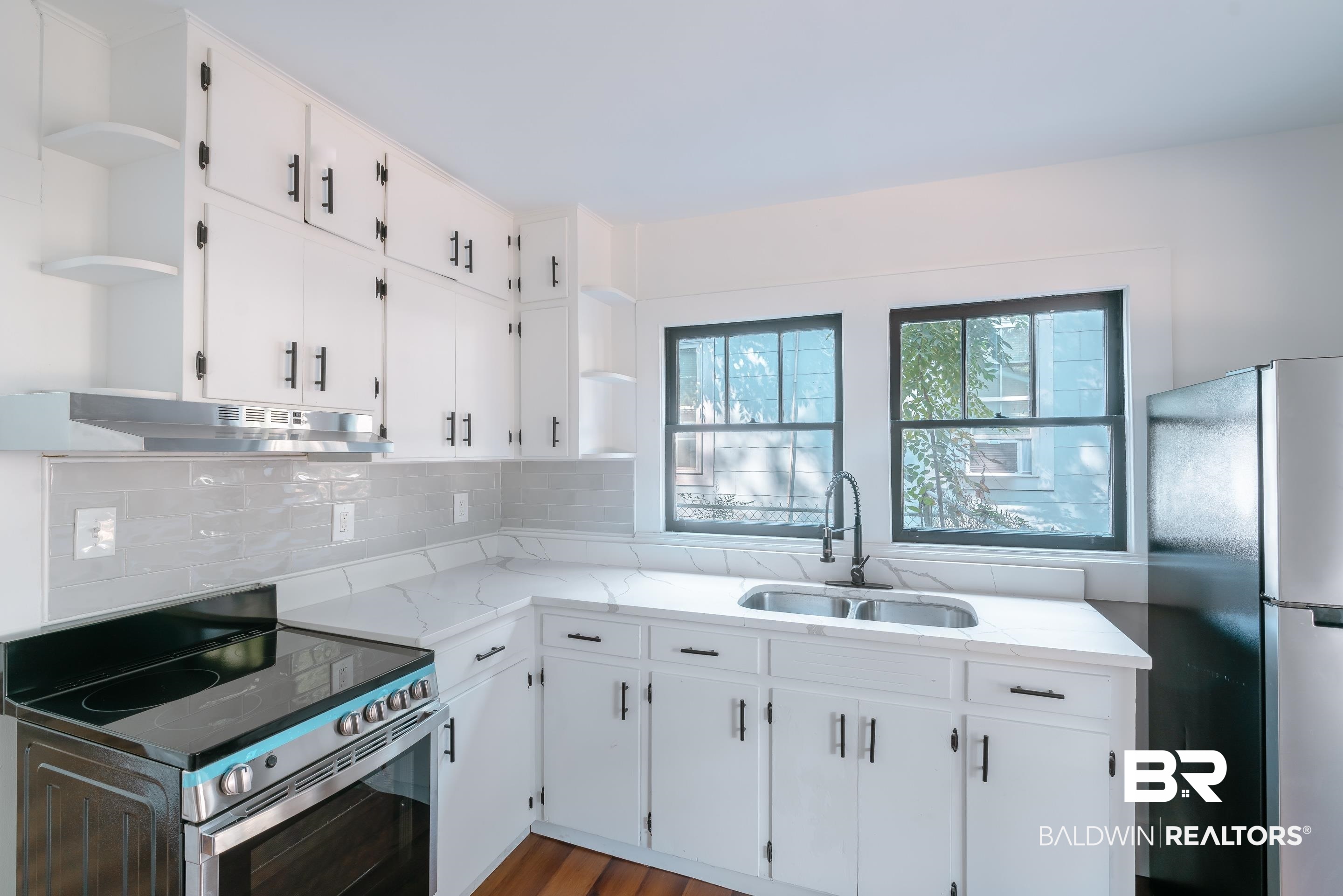 166 Crenshaw Street Mobile, AL 36606 - Photo 5 of 24 Kitchen with exhaust hood, white cabinetry, sink, light hardwood / wood-style floors, and stainless steel appliances