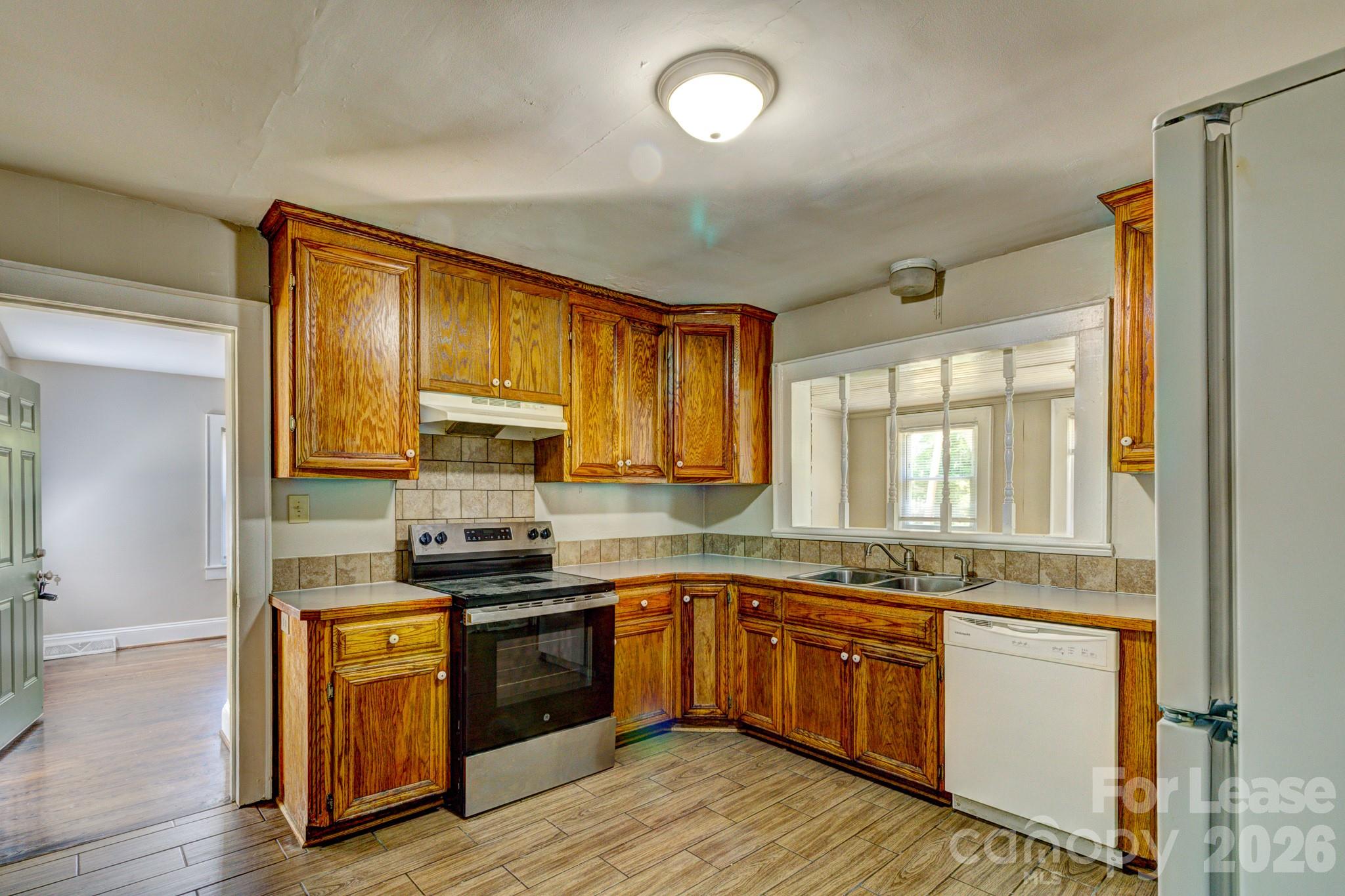 1006 Delview Road Cherryville, NC 28021 - Photo 6 of 10 a kitchen with granite countertop wooden floors stainless steel appliances and sink