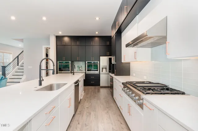 a kitchen with kitchen island granite countertop a sink stainless steel appliances and cabinets