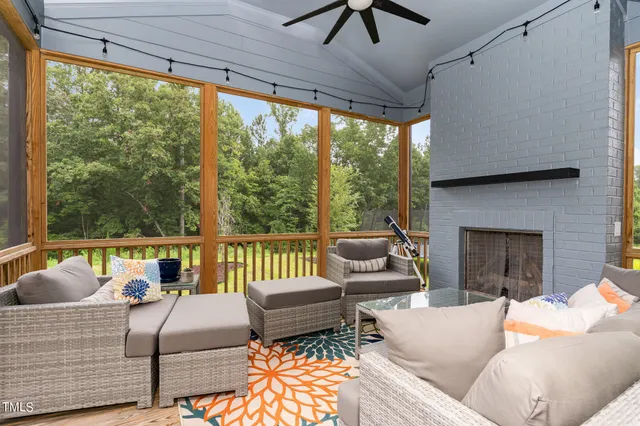 a living room with furniture a ceiling fan and a fireplace