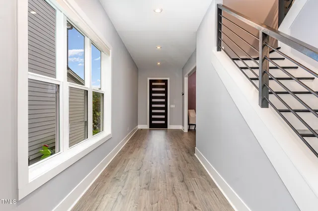a view of a hallway with wooden floor and staircase