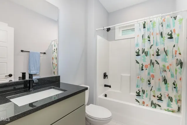 a bathroom with a granite countertop sink a toilet and a bathtub