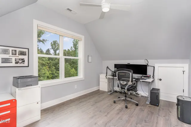 a view of a workspace with furniture and a window