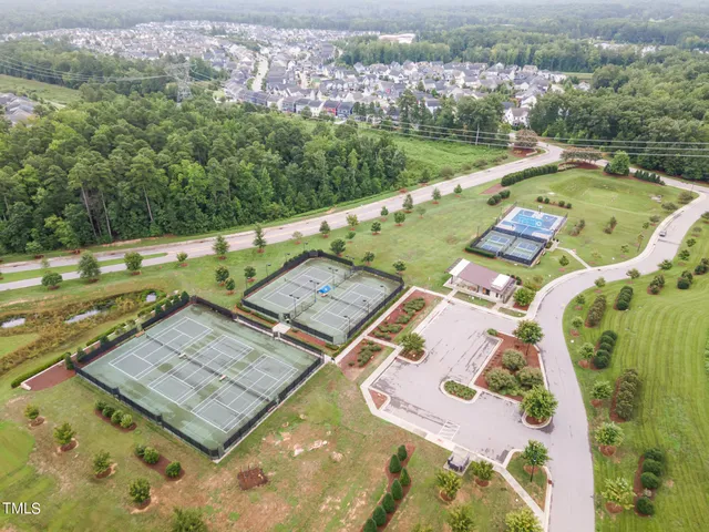 an aerial view of a pool yard and mountain view in back