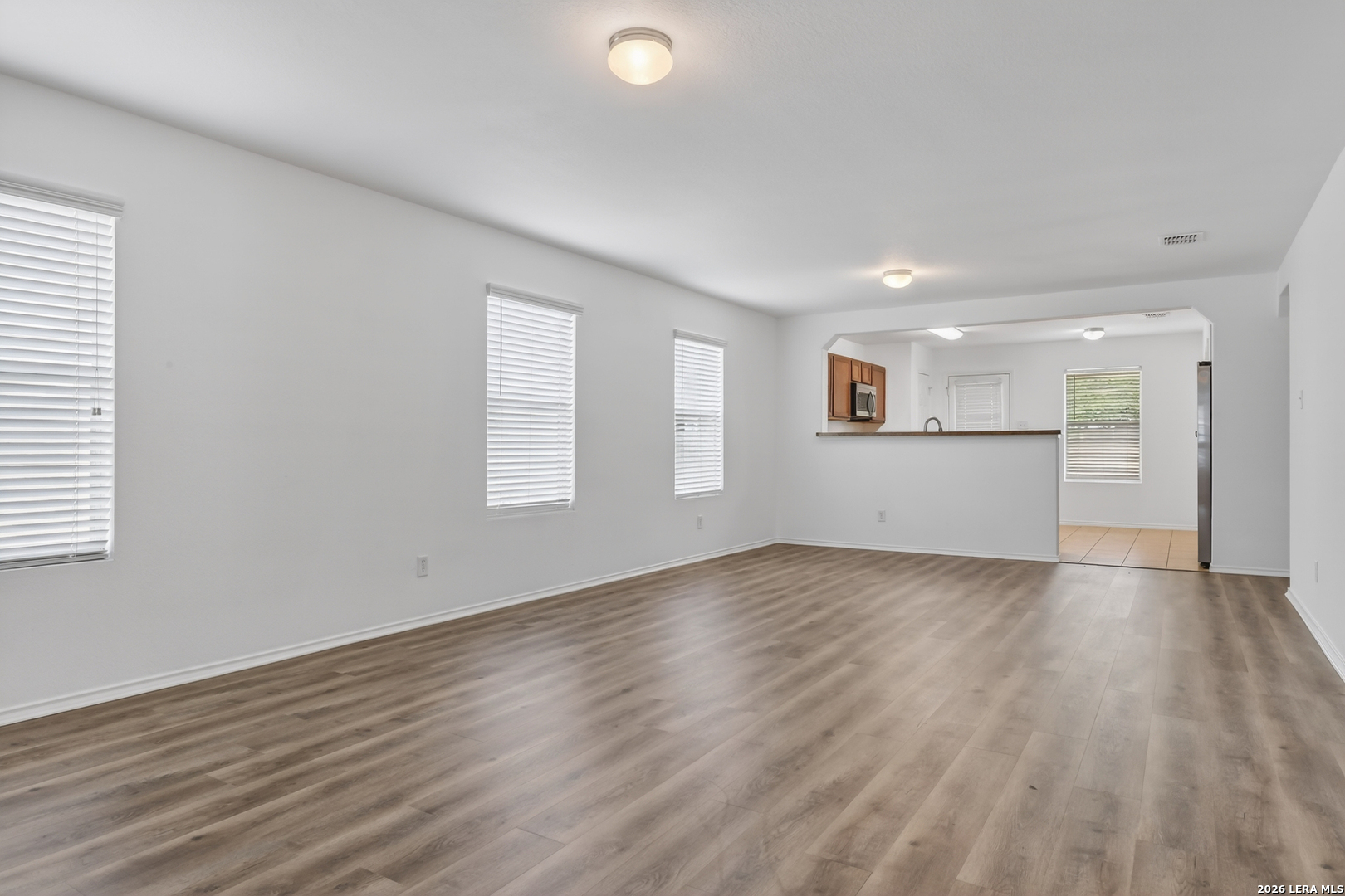 332 Lonestar Gait Selma, TX 78154 - Photo 4 of 24 an empty room with wooden floor and windows