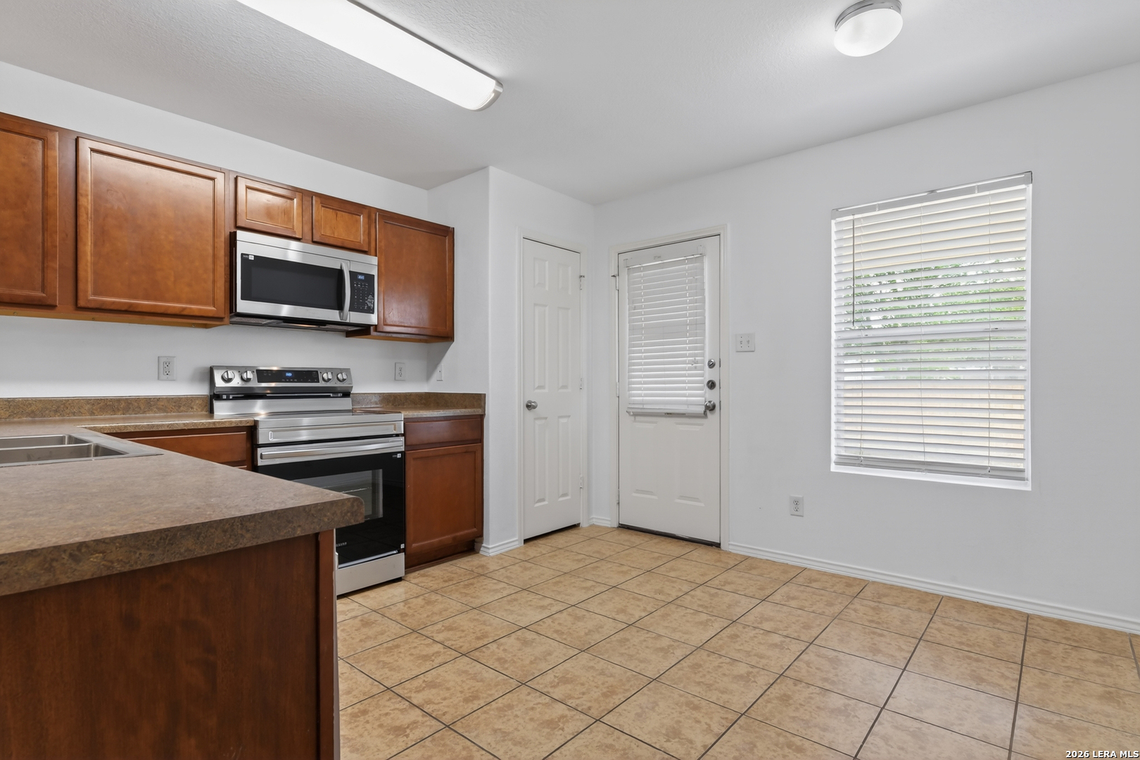 332 Lonestar Gait Selma, TX 78154 - Photo 6 of 24 a kitchen with stainless steel appliances granite countertop a stove microwave and sink