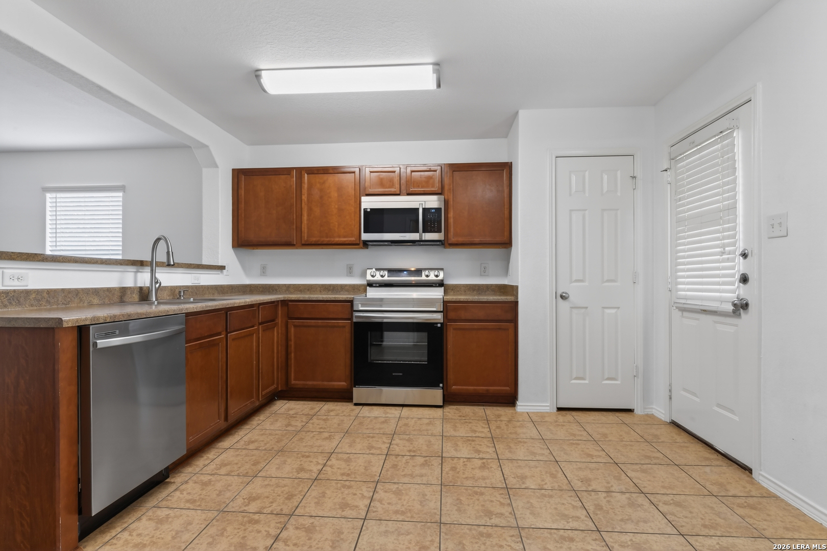 332 Lonestar Gait Selma, TX 78154 - Photo 7 of 24 a kitchen with stainless steel appliances granite countertop a stove top oven a sink and dishwasher