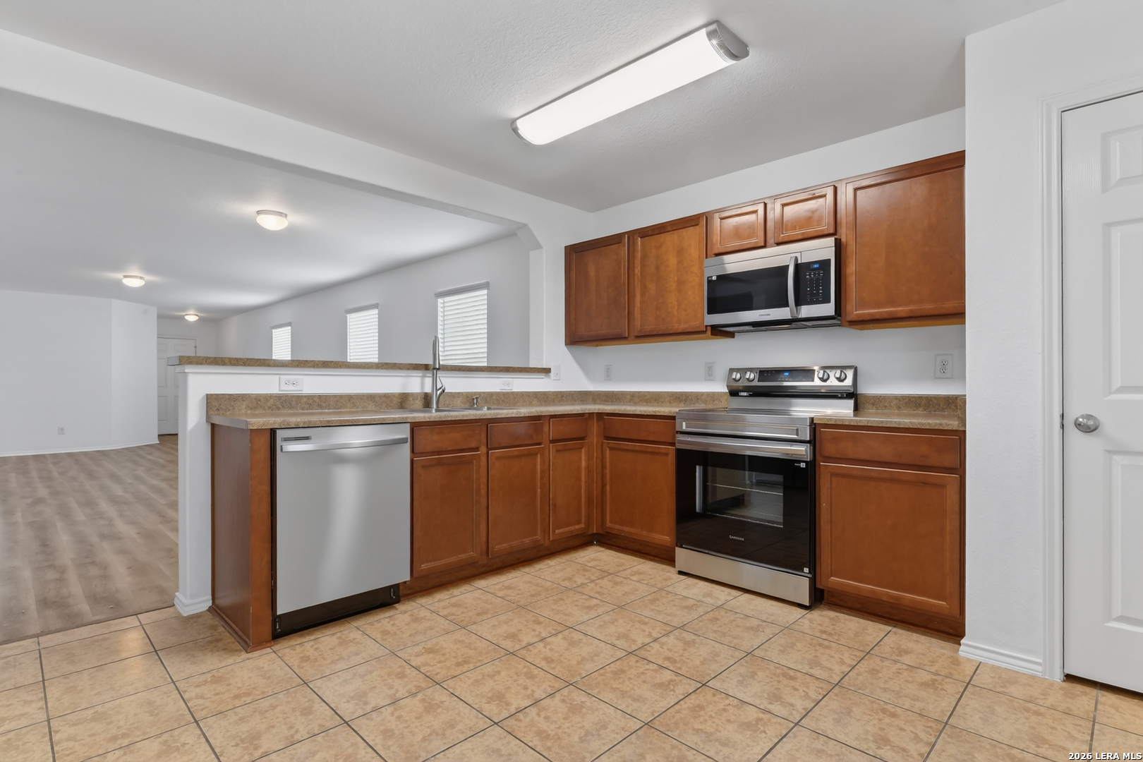 332 Lonestar Gait Selma, TX 78154 - Photo 8 of 24 a kitchen with stainless steel appliances granite countertop a stove top oven a sink and a microwave