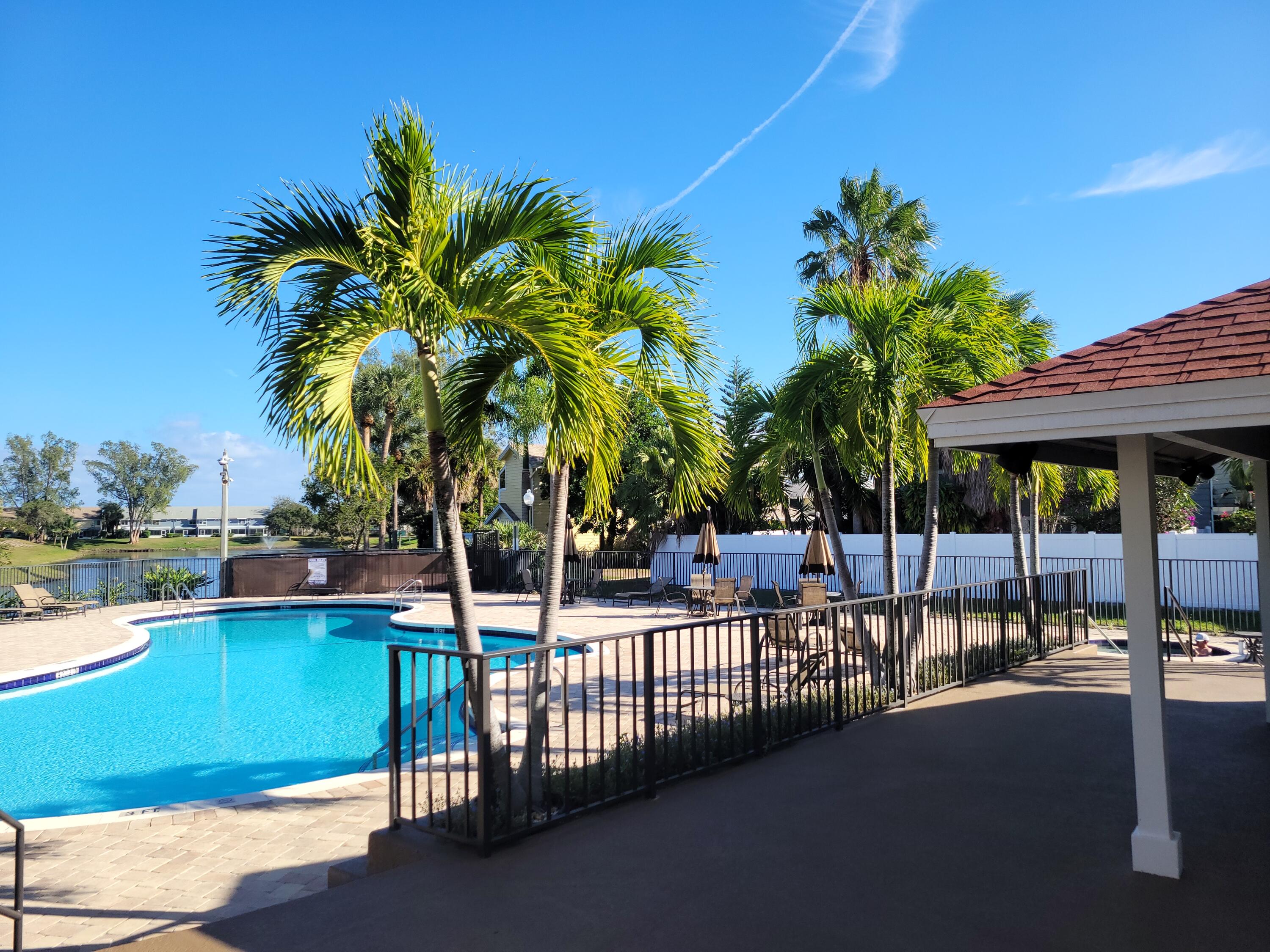 5321 Buckhead Circle, Unit 1020 Boca Raton, FL 33431 - Photo 12 of 13 a view of a swimming pool with a lawn chair and palm tree