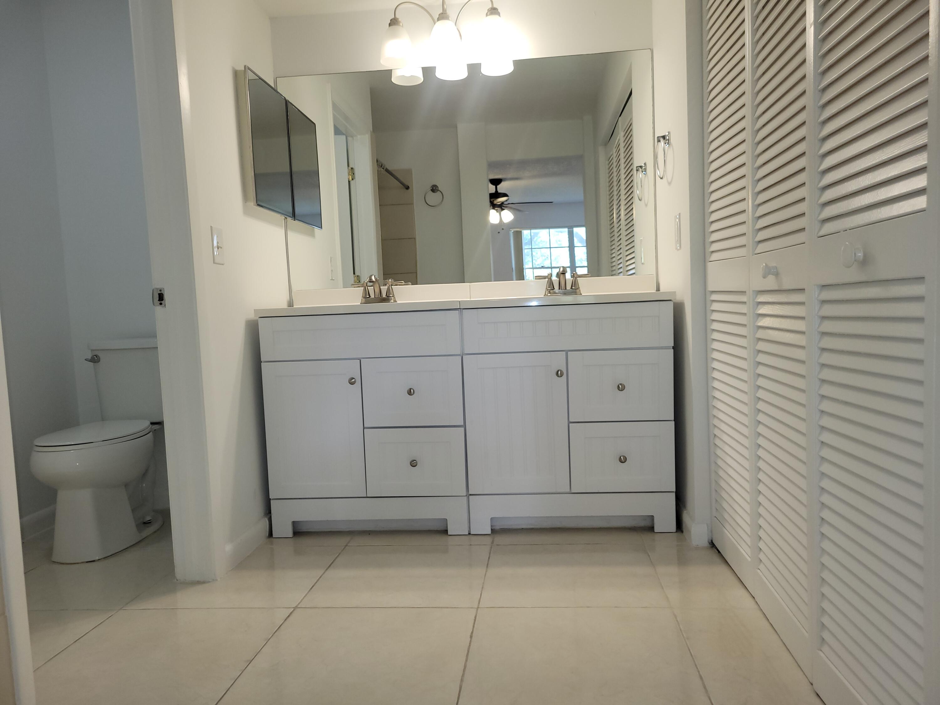 5321 Buckhead Circle, Unit 1020 Boca Raton, FL 33431 - Photo 7 of 13 a bathroom with a sink a toilet and mirror