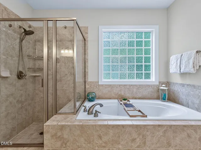 a bathroom with a tub a sink and a window