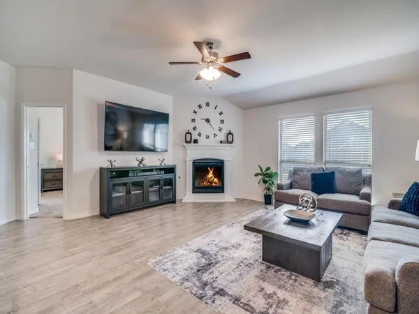 a living room with furniture a fireplace and a flat screen tv