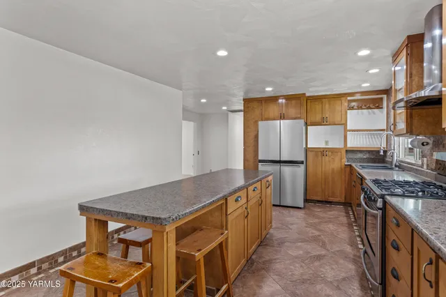 a kitchen with kitchen island granite countertop a sink window and cabinets