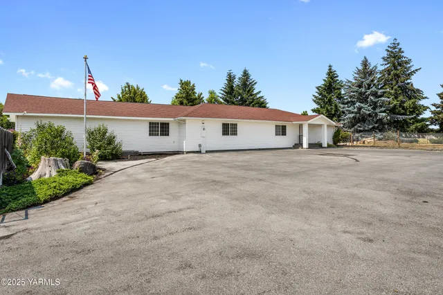 a front view of a house with a yard and trees