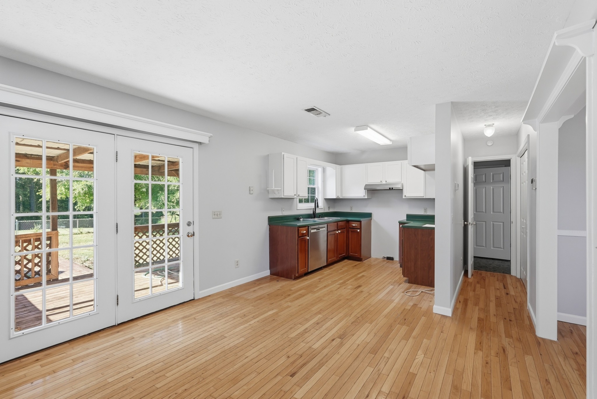 4877 Swafford Road Cookeville, TN 38501 - Photo 22 of 28 a large kitchen with stainless steel appliances granite countertop a stove a sink dishwasher a refrigerator and white cabinets with wooden floor