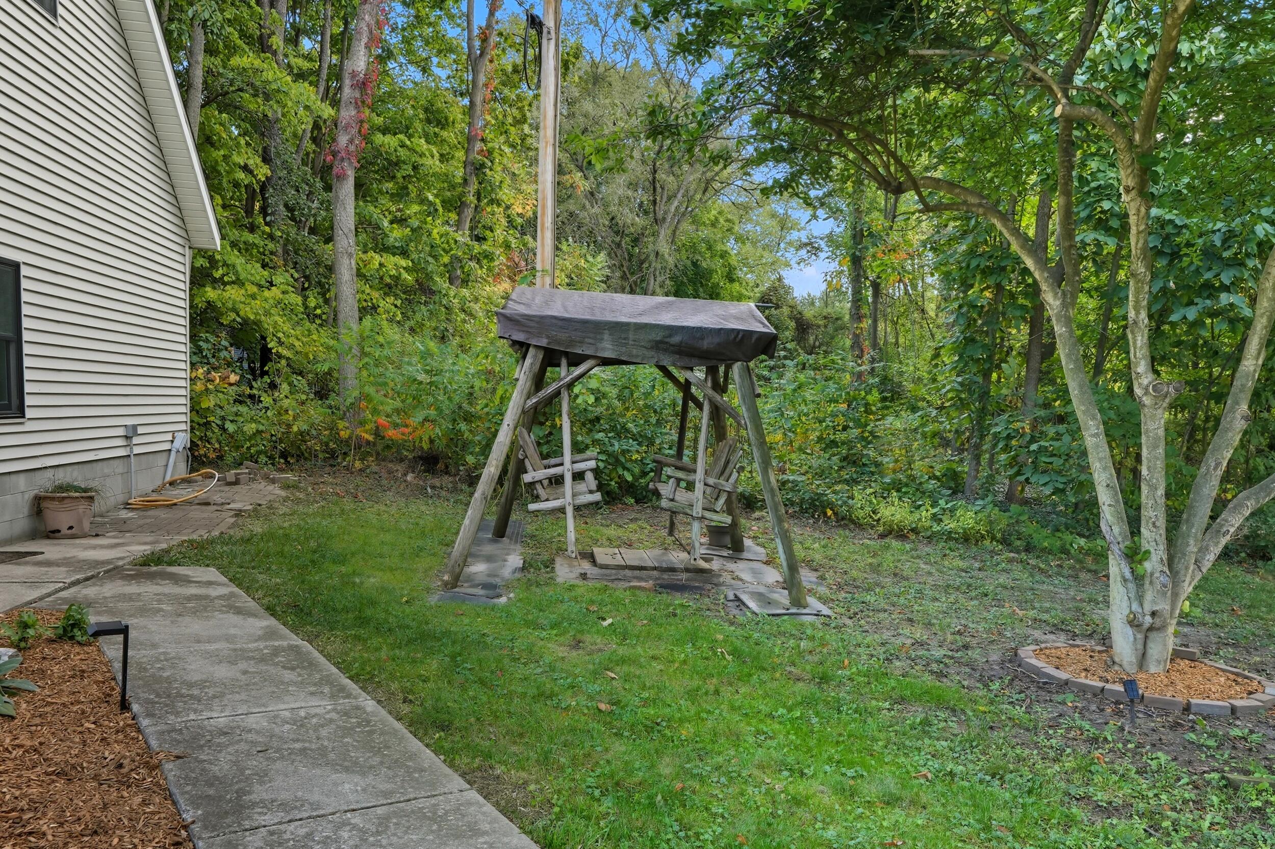 450 East Greening Road Chesterton, IN 46304 - Photo 52 of 56 a view of a backyard with a slide trees and wooden fence