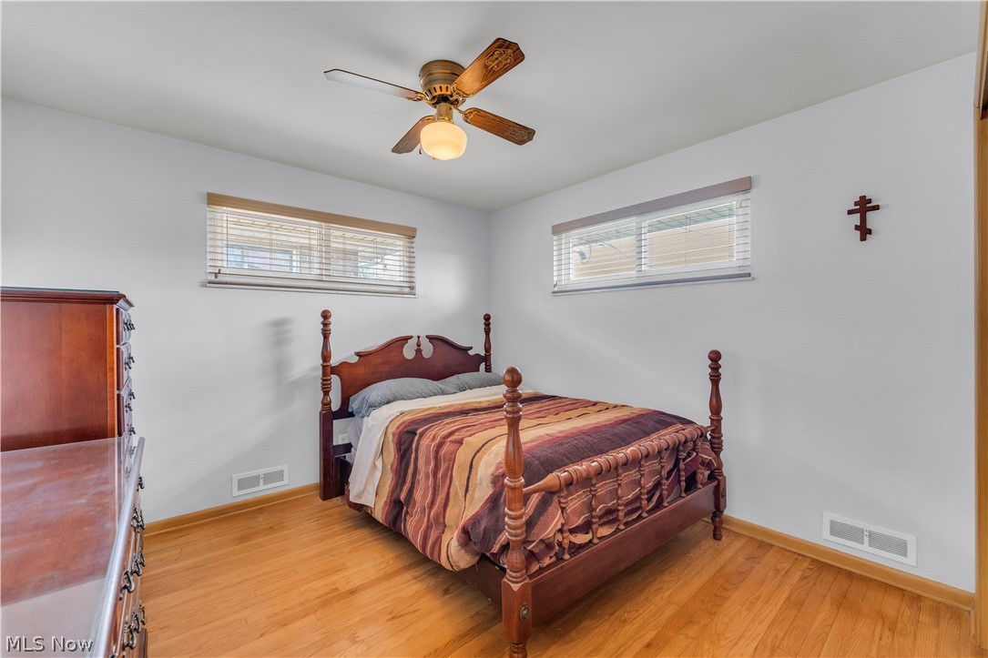 3023 Norris Avenue Cleveland, OH 44134 - Photo 18 of 41 Bright room featuring wood-finish flooring, two horizontal windows with blinds, a ceiling fan with integrated lighting, and white walls