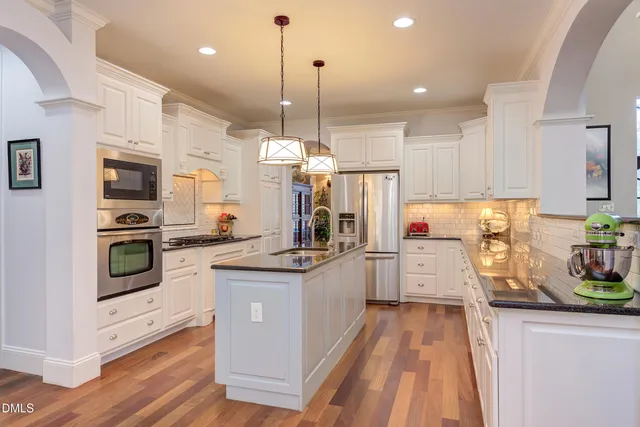 a kitchen with a sink a counter space appliances and cabinets