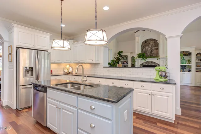 a dining room with furniture a chandelier and wooden floor