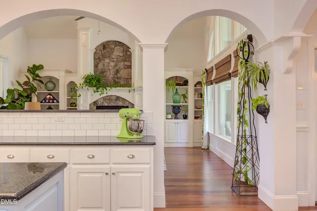 a bedroom with a large bed a fireplace and a chandelier