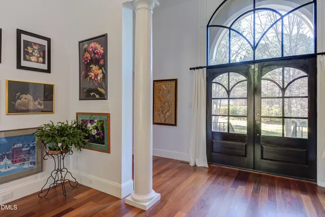 a living room with furniture a chandelier and a large window