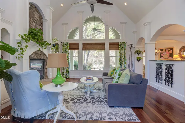 a living room with furniture a fireplace and a floor to ceiling window
