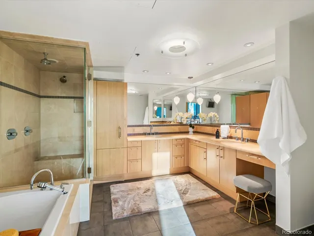 a bathroom with a tub shower vanity and a sink